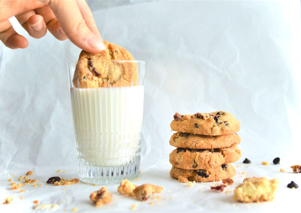 Cookie being dunked in milk.